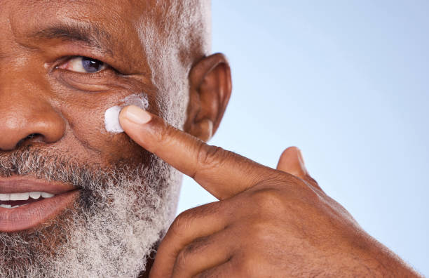black man with grey hair using moisturiser