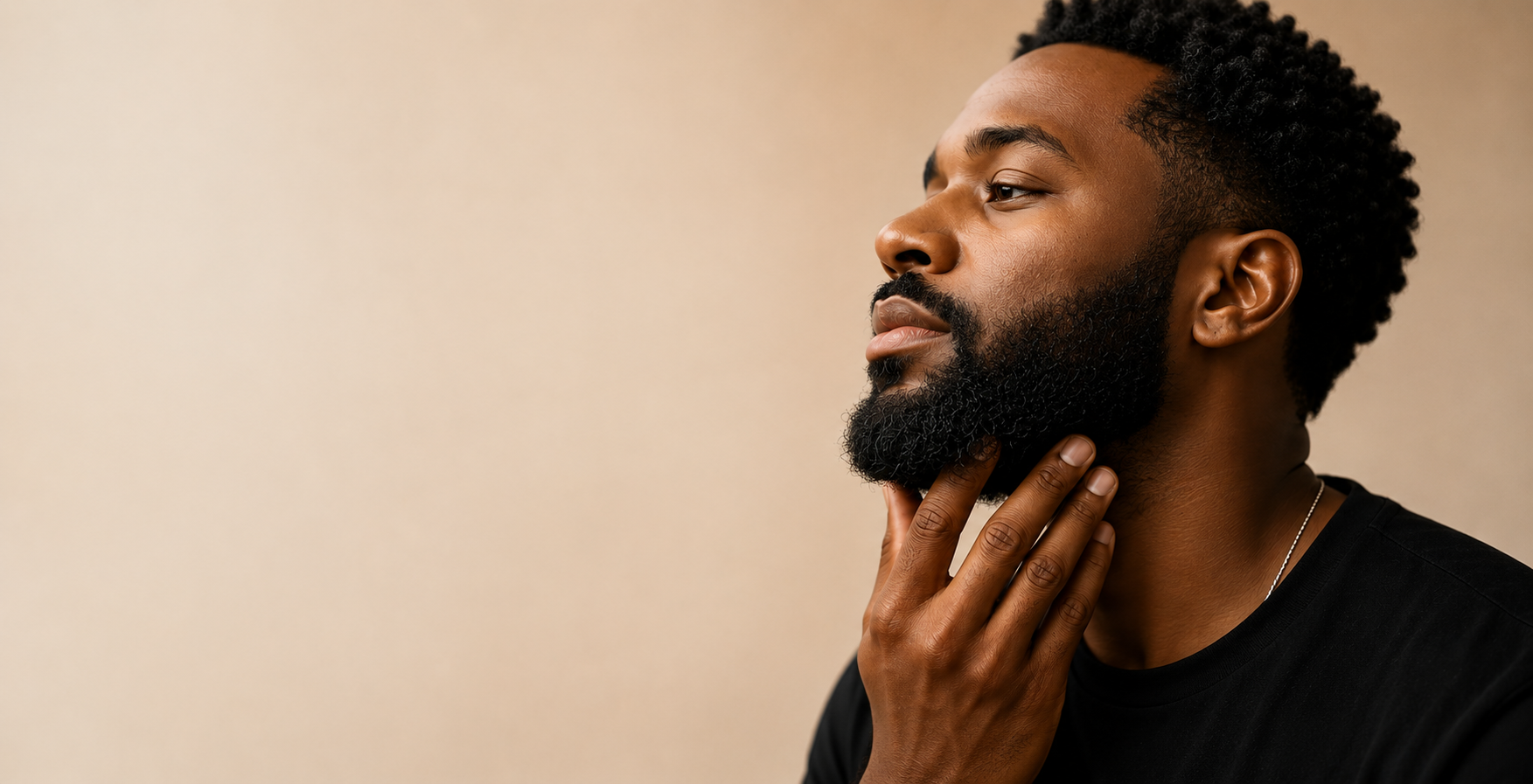 black man with hand under afro textured beard